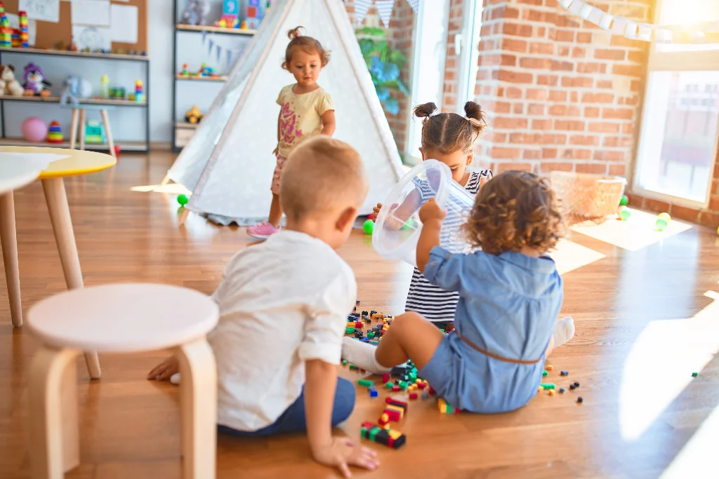 un adorable groupe de tout-petits qui s'amusent avec plein de jouets à la maternelle
